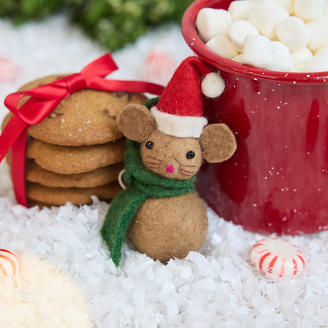 Craftspring’s Little Drop Santa Mouse Ornament — felt mouse made of felt balls, wearing a Santa hat and green scarf — styled alongside cookies and hot cocoa, capturing cozy holiday warmth, whimsical charm, and heirloom-quality Christmas gifting, ethically crafted by artisans using sustainable wool.