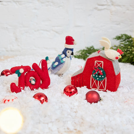 Craftspring’s Comfort and Joy Ornaments Bundle — includes Joy Berries Ornament, Santa Blue Jay Ornament, and Red Barn with Rooster Ornament — displayed together in a cozy holiday setting, highlighting playful designs with beaded and embroidered details, evoking festive warmth and heirloom-quality Christmas gifting, ethically crafted by artisans using sustainable wool.