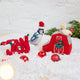 Craftspring’s Comfort and Joy Ornaments Bundle — includes Joy Berries Ornament, Santa Blue Jay Ornament, and Red Barn with Rooster Ornament — displayed together in a cozy holiday setting, highlighting playful designs with beaded and embroidered details, evoking festive warmth and heirloom-quality Christmas gifting, ethically crafted by artisans using sustainable wool.