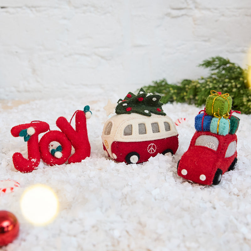 Craftspring’s Home for the Holidays Ornaments Bundle — includes Christmas Tree Hippie Bus Ornament, Joy Berries Ornament, and Santa’s Car with Presents Ornament — displayed together in a cozy holiday setting, highlighting playful designs with beaded and embroidered details, evoking festive warmth and heirloom-quality Christmas gifting, ethically crafted by artisans using sustainable wool.