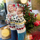 Craftspring’s NYC Holiday 100% Alpaca Sweater — soft crewneck of sustainably harvested baby alpaca wool, adorned with intricate jacquard NYC icons such as bagels, taxi cabs, and pigeons — heirloom-quality holiday knitwear, ethically crafted by artisans in Peru. Two kids wear the sweaters in front of a Christmas tree, radiating festive cheer and Christmas gifting spirit.