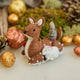 Handmade felt Sitting Deer with Friends Ornament from Craftspring, featuring a deer, rabbit, squirrel, and bird surrounded by beaded snow—displayed in a festive woodland holiday scene with golden walnuts and moss, perfect for Christmas gifting, ethically crafted by artisans using sustainable wool.