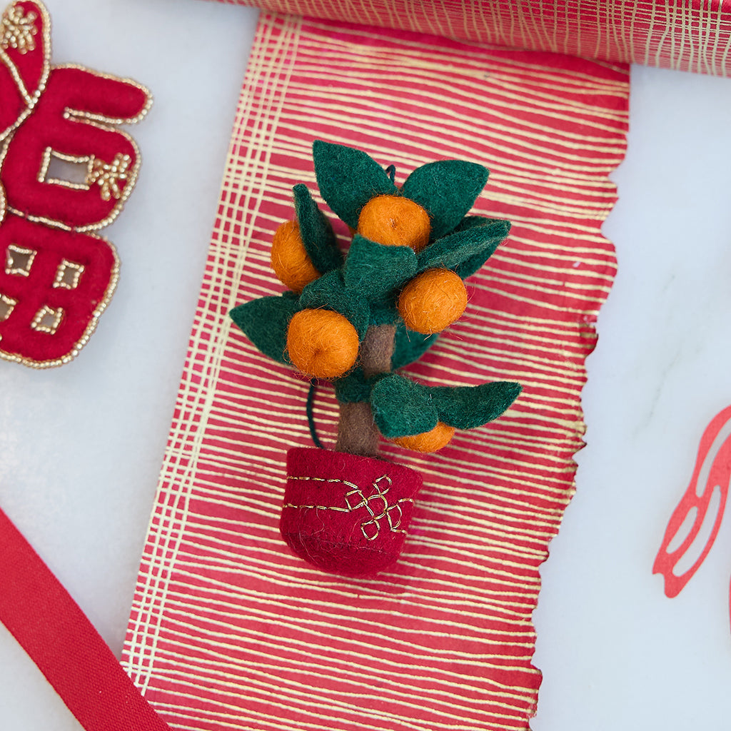 Handmade felt Clementine Tree Ornament from Craftspring, featuring a red pot with gold embroidery and a tree with eight bright clementines — heirloom-quality Lunar New Year decor, a joyful symbol of abundance and gifting, ethically crafted by artisans using sustainable wool.