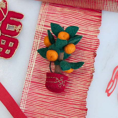 Handmade felt Clementine Tree Ornament from Craftspring, featuring a red pot with gold embroidery and a tree with eight bright clementines — heirloom-quality Lunar New Year decor, a joyful symbol of abundance and gifting, ethically crafted by artisans using sustainable wool.