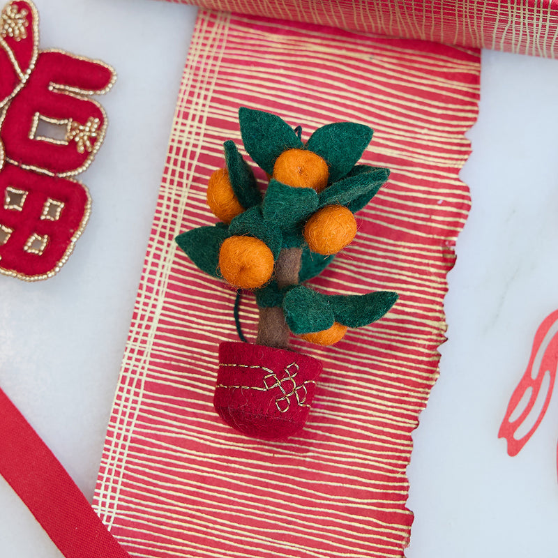Handmade felt Clementine Tree Ornament from Craftspring, featuring a red pot with gold embroidery and a tree with eight bright clementines — heirloom-quality Lunar New Year decor, a joyful symbol of abundance and gifting, ethically crafted by artisans using sustainable wool.