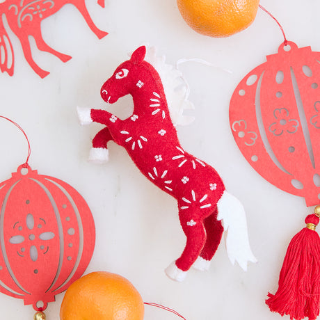 Chinese Red Horse Ornament displayed with paper lanterns, highlighting its beaded and embroidered Lunar New Year details for festive gifting and decor.
