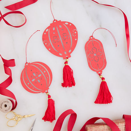 Paper Lantern Ornaments displayed with bright red ribbon, highlighting their festive paper craftsmanship. Ethically handmade by artisans for meaningful Lunar New Year celebrations.