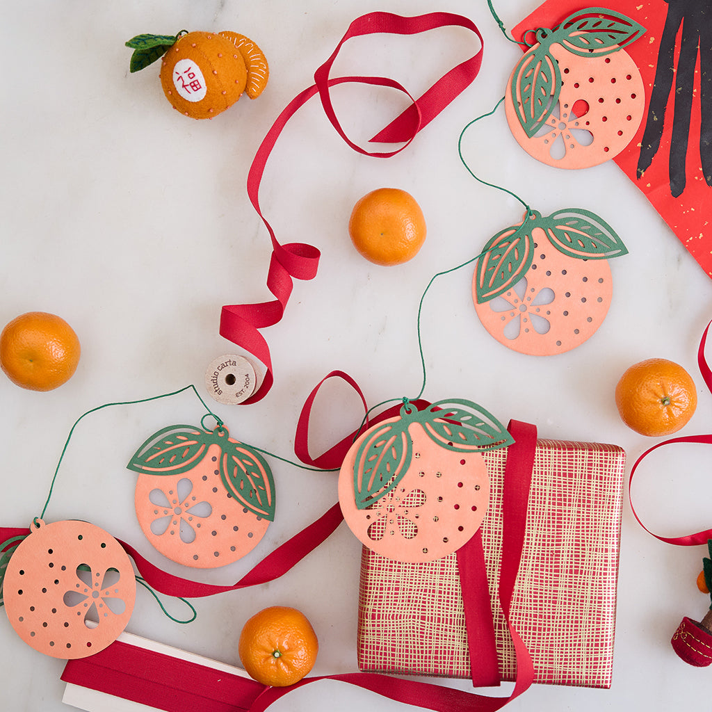 Paper Clementine Garland — set of 2 handmade garlands, each with 5 clementines featuring leaves and intricate cutout details, ethically handmade by artisans from recycled cotton waste — festive Christmas, holiday, and Lunar New Year decor, perfect for joyful gifting.