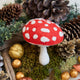 Handmade felt Woodland Amanita Mushroom Ornament from Craftspring, with applique and embroidered details—displayed among golden nuts and moss, festive woodland holiday decor, heirloom-quality, ethically handcrafted by artisans using sustainable wool.