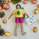 Handmade felt On the Trail Backpacker Ornament – Brown from Craftspring, backpacker girl with map and colorful hiking clothes—displayed among golden nuts in a festive holiday scene, heirloom-quality Christmas decor, ethically handcrafted by artisans.