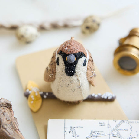 Celebrate the quiet beauty of everyday birds with our Sparrow Ornament. Small yet full of personality, this beloved garden bird is lovingly hand-felted from natural wool and perched on a delicate felt branch.