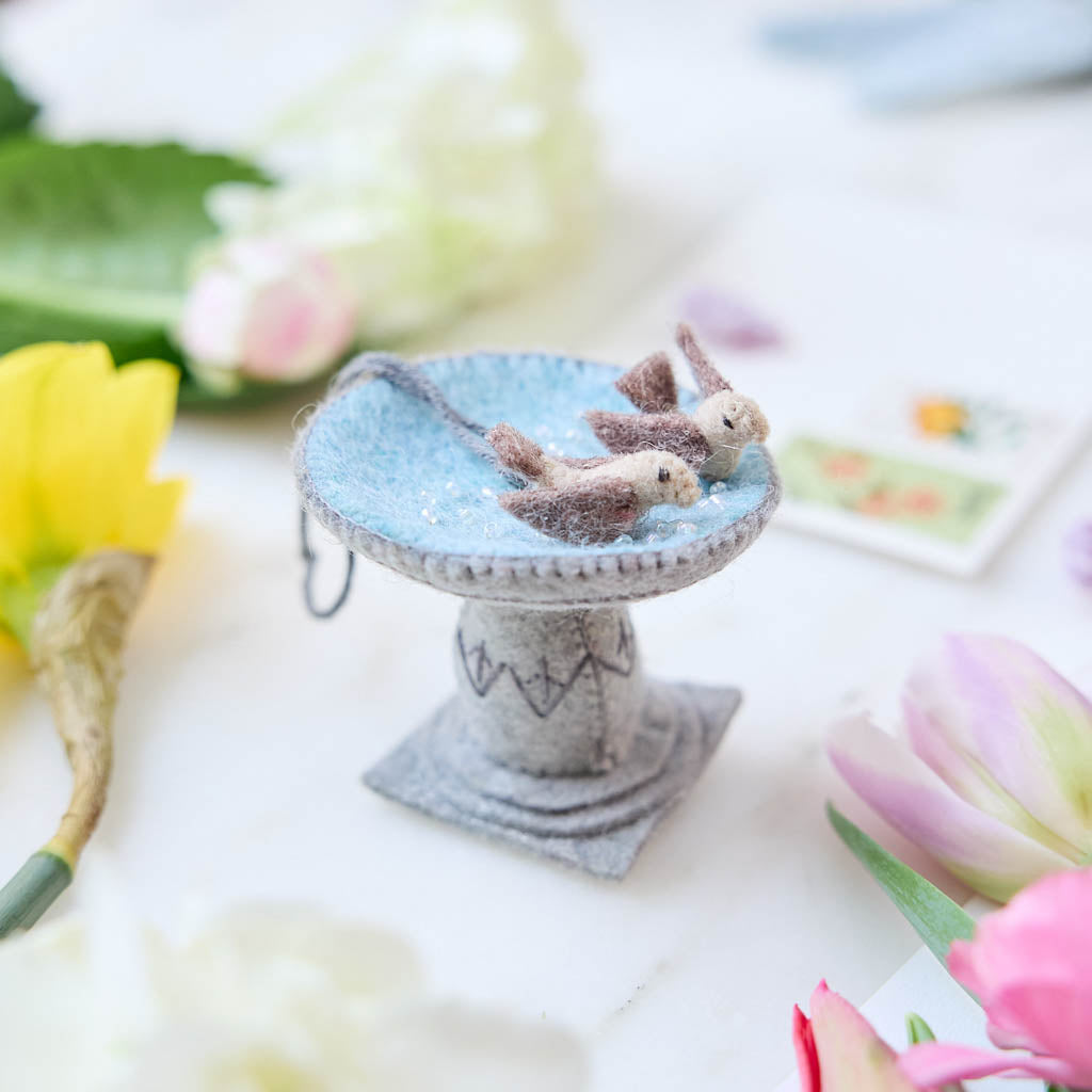 Celebrate the gentle rhythms of the garden with our Bird Bath Ornament. This charming felt scene features two tiny birds enjoying a quiet splash, capturing the simple joy of watching backyard birds gather for a drink on a sunny day.