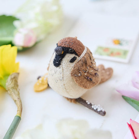 Celebrate the quiet beauty of everyday birds with our Sparrow Ornament. Small yet full of personality, this beloved garden bird is lovingly hand-felted from natural wool and perched on a delicate felt branch.