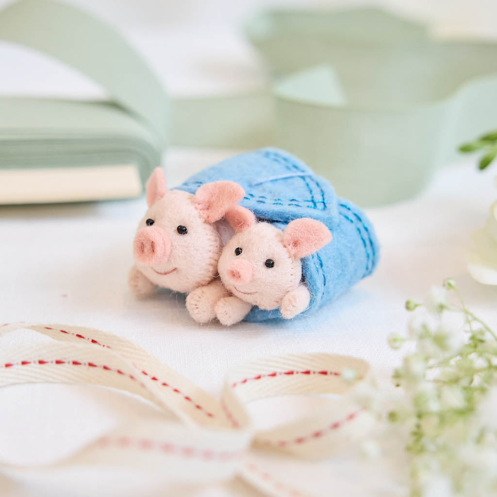 Cozy, cuddly, and completely irresistible—our Pigs in a Blanket Ornament is here to wrap your holidays in pure joy. Featuring a sweet pig parent and baby snuggled snugly inside a soft blue “blanket,” this playful design brings together comfort, humor, and heartfelt connection in the most delightful way.