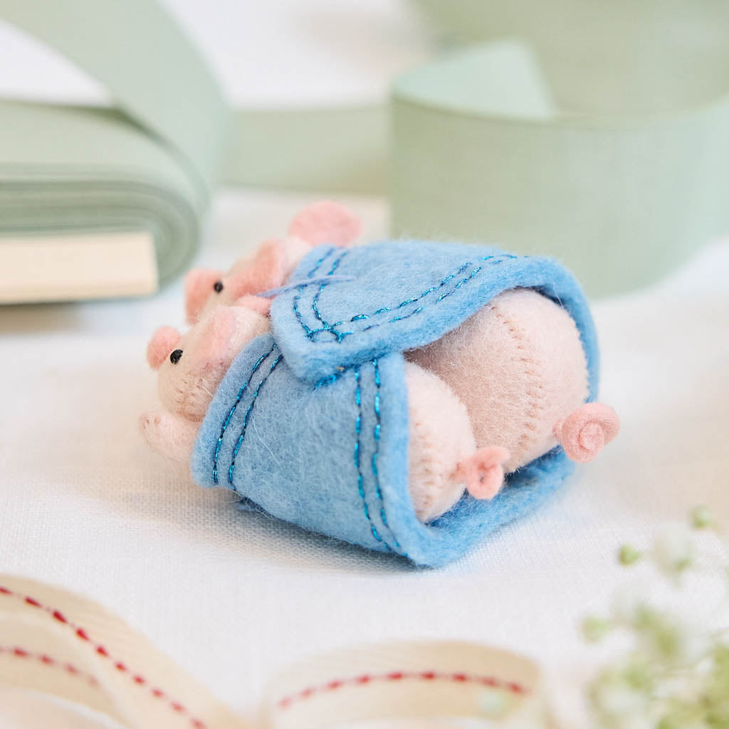 Cozy, cuddly, and completely irresistible—our Pigs in a Blanket Ornament is here to wrap your holidays in pure joy. Featuring a sweet pig parent and baby snuggled snugly inside a soft blue “blanket,” this playful design brings together comfort, humor, and heartfelt connection in the most delightful way.