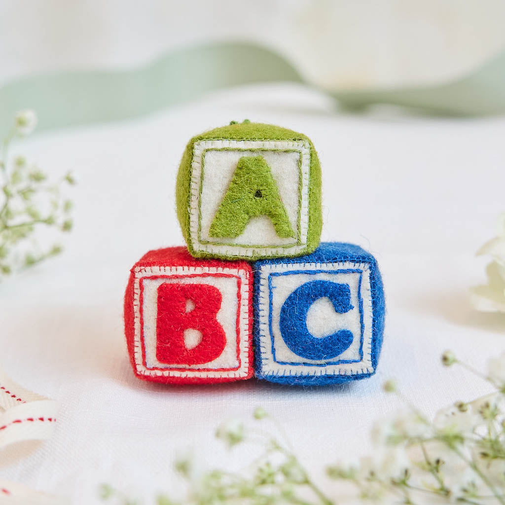 A classic welcome for baby! Our handmade felt ABC blocks ornament is designed as a baby keepsake, perfect for baby showers, newborn gifts, and a baby’s first Christmas.