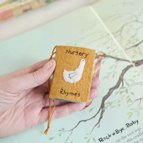 handcrafted miniature nursery rhymes book celebrating classic childhood tunes and stories, ready to hang on the tree or in the nursery!