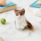Celebrate the unique beauty of feline companions with our felt Calico Cat Ornament. Carefully handcrafted by skilled artisans, this elegant ornament features the signature patchwork of warm browns, soft whites, and golden tones that make calico cats so beloved.