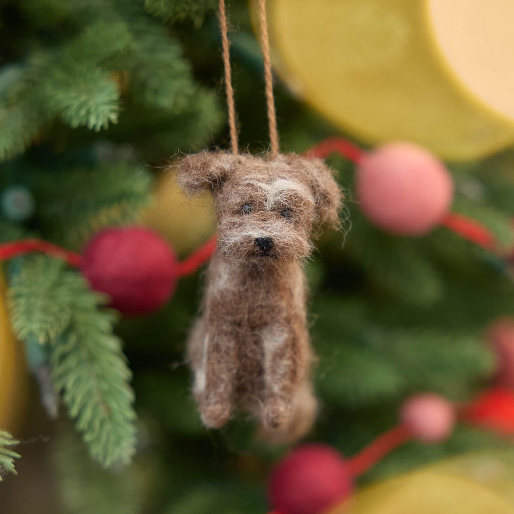 Celebrate the one-of-a-kind charm of man’s best friend with our felt Scruffy Mutt Ornament. Handcrafted by skilled artisans, this adorable pup features a tousled coat, floppy ears, and a sweet, soulful expression that captures the personality of beloved mixed-breed dogs everywhere.