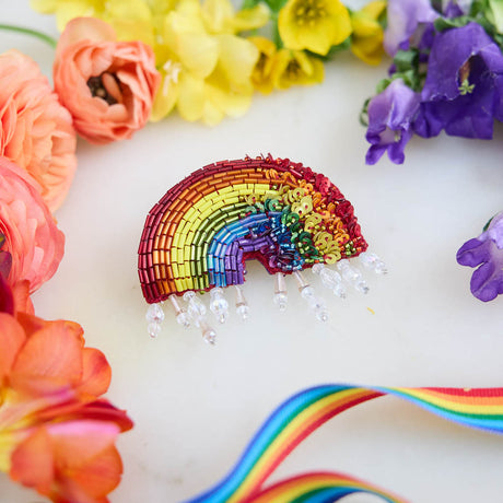 Handcrafted with shimmering beads in bold rainbow arches, this colorful ornament captures the joy, resilience, and beauty of the Pride movement. Sparkling crystal accents cascade beneath the rainbow like drops of light, adding texture, movement, and eye-catching detail.
