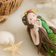Add a touch of ocean magic to your Christmas tree with our beautiful Siren Mermaid Ornament. Lovingly handcrafted from eco-friendly wool felt, this elegant mermaid features flowing brunette hair, a vibrant green tail adorned with sparkling bead accents, and charming floral details inspired by the treasures of the sea.