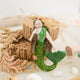 Add a touch of ocean magic to your Christmas tree with our beautiful Siren Mermaid Ornament. Lovingly handcrafted from eco-friendly wool felt, this elegant mermaid features flowing brunette hair, a vibrant green tail adorned with sparkling bead accents, and charming floral details inspired by the treasures of the sea.