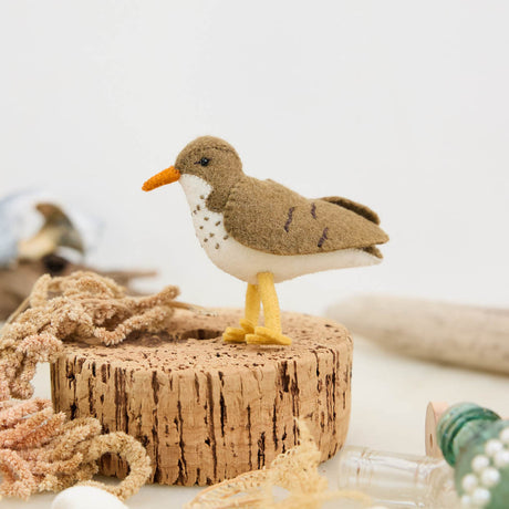 Bring a touch of the shoreline to your holiday décor with our delightful Spotted Sandpiper Ornament. Carefully handcrafted from eco-friendly wool felt, this charming bird captures the distinctive features of the beloved sandpiper, from its warm brown plumage and bright orange beak to its delicate spotted breast.