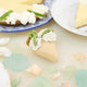 Capture the sweet taste of the Florida Keys with our handcrafted Key Lime Pie Slice Felt Ornament, a delightful dessert-inspired decoration featuring fluffy whipped cream, vibrant lime accents, and realistic pie slice details. Handmade from sustainable wool felt by women artisans, this whimsical ornament celebrates one of America's most beloved tropical desserts and adds a playful touch to holiday décor.