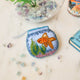 Make a splash with our whimsical Fishbowl Beaded Ornament! 🐠✨ This beautifully handcrafted ornament captures the charm of a beloved goldfish swimming peacefully through its miniature underwater world. Featuring a shimmering sequined goldfish, vibrant hand-beaded aquatic plants, and a sparkling fishbowl outlined with delicate glass beads, every detail is carefully stitched by hand to create a dazzling keepsake.
