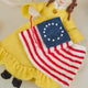 Celebrate the legendary maker associated with America’s first flag with our handcrafted Betsy Ross Ornament. Dressed in a bright colonial gown and holding the iconic early American flag, Betsy honors the spirit of independence, ingenuity, and handmade tradition.