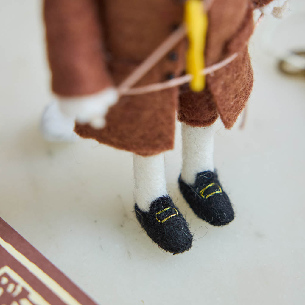 Honor the brilliance and ingenuity of a true American icon with our handcrafted Benjamin Franklin Ornament from the Craftspring Semiquincentennial Collection. Featuring Franklin in his classic colonial attire while flying a kite with a key
