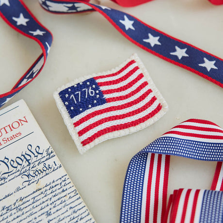 Honor the spirit of 1776 with our handcrafted 1776 American Flag Ornament from the Craftspring Semiquincentennial Collection. Inspired by the early American flag associated with the Revolutionary era, this felt ornament features embroidered red and white stripes, a blue canton with stars, and the year “1776” stitched proudly across the center—commemorating the birth of the United States. 