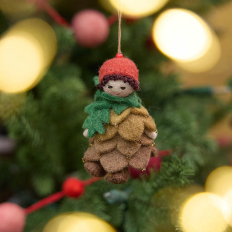 Waldorf-inspired, our Little Pinecone Kid Ornament captures the whimsical spirit of a woodland fairy tale. With its cute woolen bonnet, it's pine-green scarf and lovely layered pinecone petals and sweet as can be felted booties - this pinecone child is ready to capture woodland hearts.