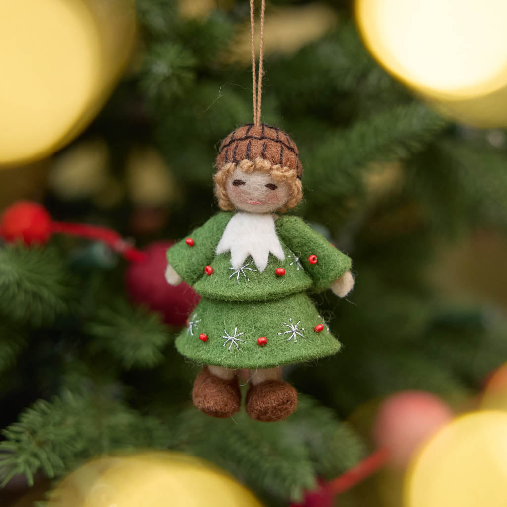 Inspired by the gentle wonder of Waldorf traditions, our Little Acorn Kid Ornament captures the whimsical spirit of a woodland fairy tale. Wearing an adorable felted acorn cap and a charming oak-leaf skirt.