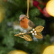 A vintage-inspired Robin Ornament, featuring a hand-painted red-breasted bird perched on a golden metal holly branch with white berries.