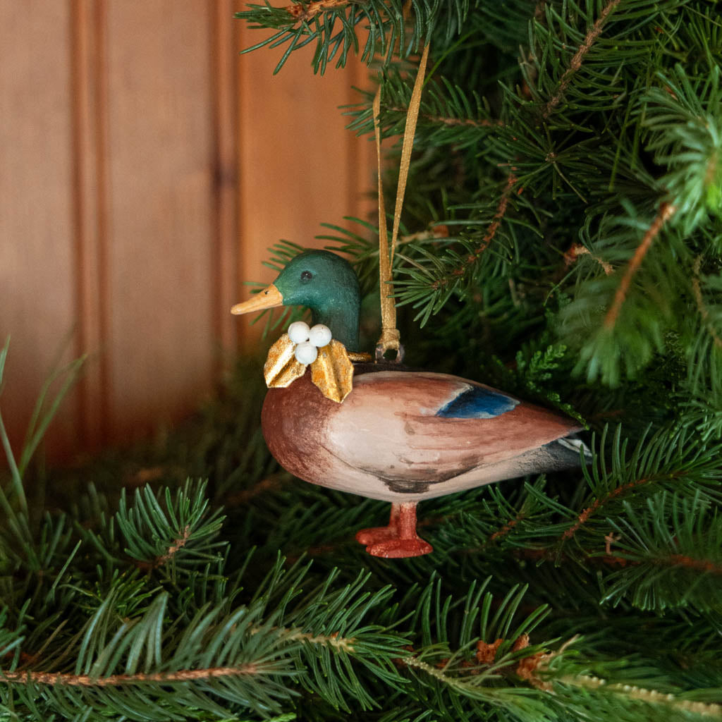 A vintage-inspired Mallard Duck Resin Ornament, hand-painted in the Philippines with a golden metal holly necklace and satin hanging ribbon.