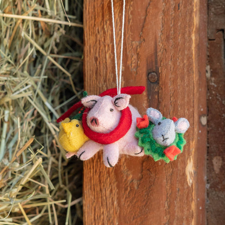  Our Festive Farm Animals Ornament brings together an adorable pink pig, a fluffy yellow chick, and a sweet gray bunny, all bundled up for the holidays. The pig wears a cozy red scarf with festive holly leaves, while the bunny sports a whimsical green holiday wreath with bright red bows. 