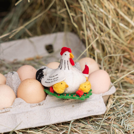 Gathered together on a festive green wreath our Holiday Hen with Chicks Ornament is a sweet celebration of family, nurturing, and holiday togetherness. A proud mother hen watches over her fluffy yellow chicks, while one festive little chick sports a tiny red Santa hat, adding an extra dash of Christmas cheer. 