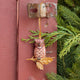A vintage-inspired Great Horned Owl Resin Ornament, hand-painted in the Philippines and perched on a golden metal oak branch with sculpted leaves.