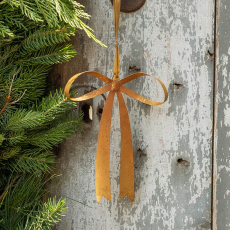 Add a graceful finishing touch to your holiday decor with our Festive Bow Metal Ornament. Beautifully handmade in the Philippines, this classic golden bow is crafted from hand-embossed iron and finished with a softly aged sheen for the look of a treasured vintage decoration.