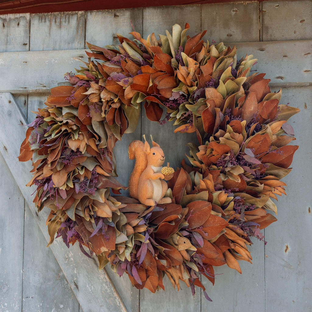 Our Squirrel Tree Topper is a handmade wool felt Christmas decoration featuring a beautifully embroidered bushy tail and golden beaded acorn, designed to perch atop your holiday tree or stand on its own as whimsical woodland décor.