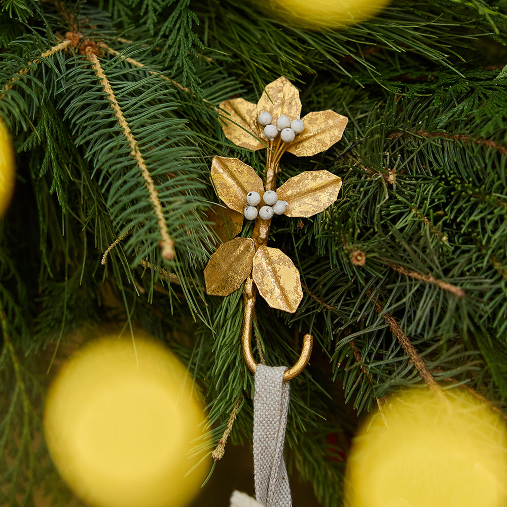 Deck the mantel! Our Holly Metal Stocking Holder turns a holiday essential into a little piece of botanical beauty, with golden holly leaves and clusters of snowy white berries handcrafted in metal.