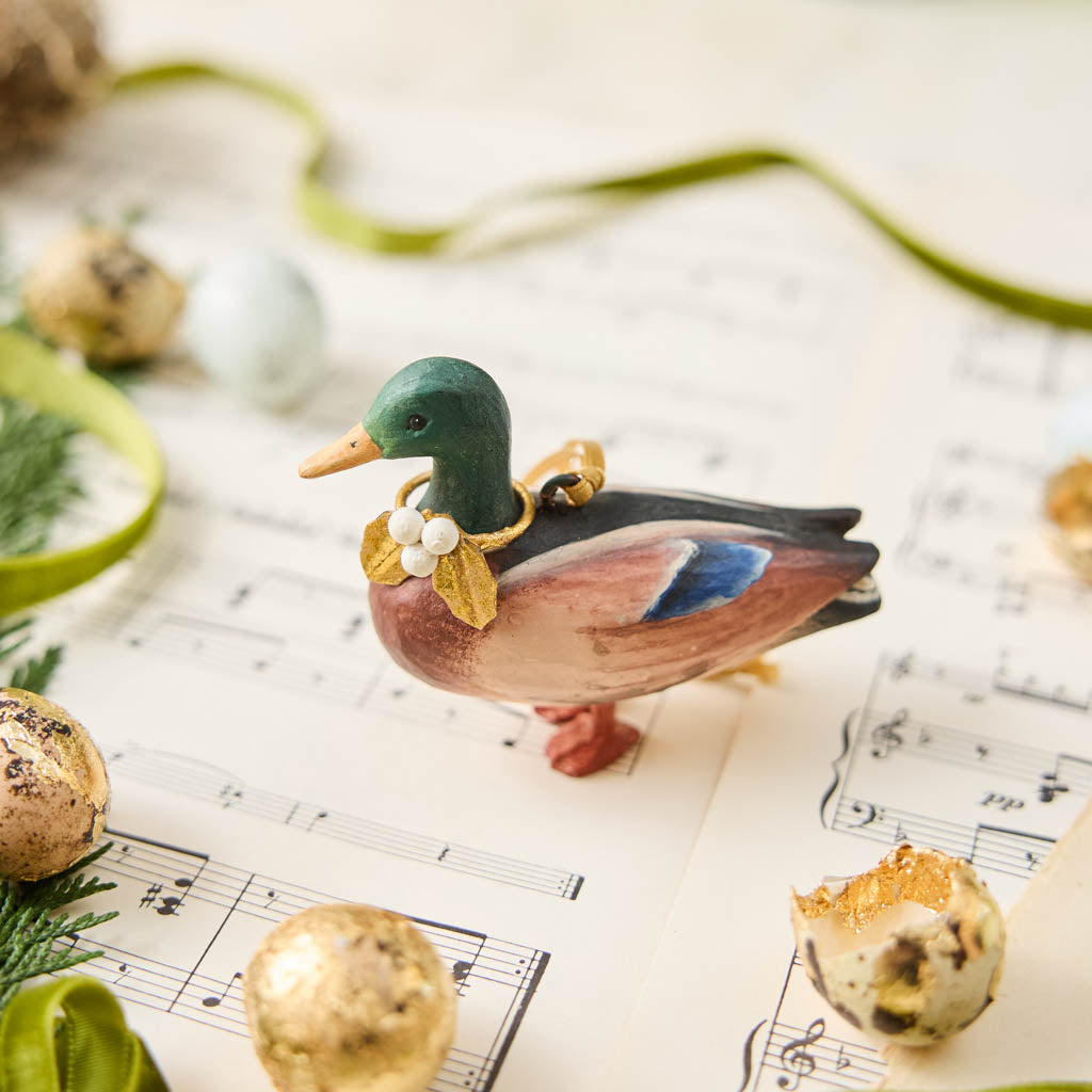 A vintage-inspired Mallard Duck Resin Ornament, hand-painted in the Philippines with a golden metal holly necklace and satin hanging ribbon.