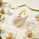 A handmade Holle Cropper Pigeon Ornament featuring a hand-painted resin bird with a distinctive puffed chest, creamy white plumage, and satin hanging ribbon.