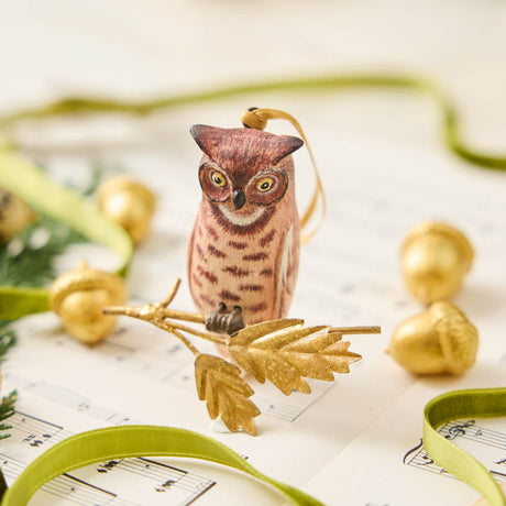 A vintage-inspired Great Horned Owl Resin Ornament, hand-painted in the Philippines and perched on a golden metal oak branch with sculpted leaves.