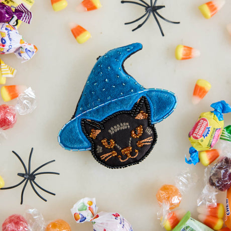 A double-sided handmade Black Cat Beaded Ornament featuring an intricately embroidered cat in a sparkling blue witch hat, with a playful “Boo” on the reverse.
