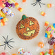 A vintage-inspired handmade beaded Jack O’Lantern Ornament featuring a smiling embroidered pumpkin face on one side and festive “Trick or Treat” detailing on the reverse.