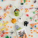 A handmade felt Halloween Mini Ornaments Set featuring five tiny spooky-season favorites: a black cat, candy-filled monster bucket, ghost, jack-o’-lantern, and RIP tombstone.