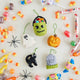 A handmade felt Halloween Mini Ornaments Set featuring five tiny spooky-season favorites: a black cat, candy-filled monster bucket, ghost, jack-o’-lantern, and RIP tombstone.