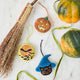 A vintage-inspired handmade beaded Jack O’Lantern Ornament featuring a smiling embroidered pumpkin face on one side and festive “Trick or Treat” detailing on the reverse.